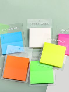 several sticky notes are stacked on top of each other in different colors and shapes,