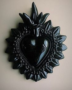 a black heart shaped object hanging on the wall