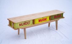 a wooden bench with two different colored labels on it's sides and the word mundet written in large letters