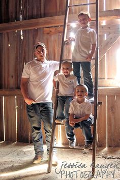 three young boys are standing on a ladder