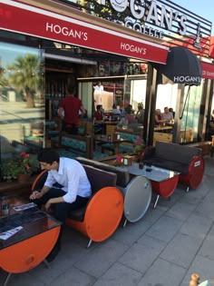 a man sitting on an orange chair in front of a restaurant