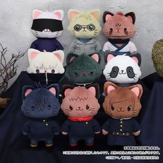 a group of stuffed animals sitting next to each other on a black cloth covered surface