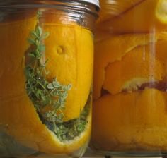 two jars filled with oranges and herbs