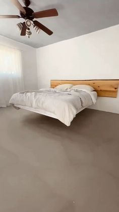 an empty bedroom with a bed and ceiling fan