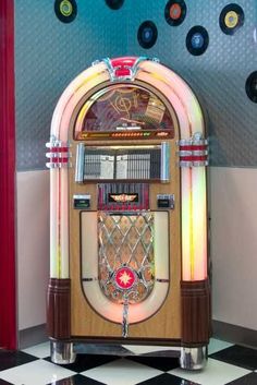 an old fashioned jukebox sitting on top of a checkered floor