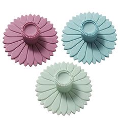 three flower shaped hair clips in various colors