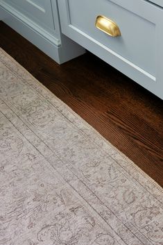 an area rug is placed on the floor in front of a cabinet and countertop