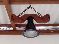 a light that is hanging from a beam with chains on the top and below it