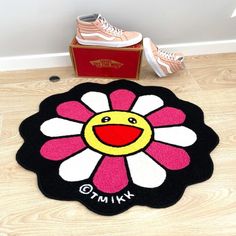 a pair of sneakers sitting on the floor next to a pink and white flower rug