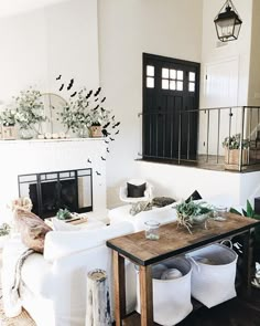 a living room filled with furniture and a fire place in front of a white wall