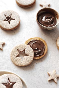 cookies with chocolate icing and stars on them are arranged next to each other in bowls