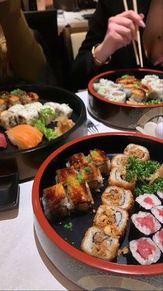 several plates of sushi and chopsticks on a table