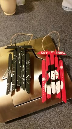 an ornament made out of popsicle sticks with a snowman on it