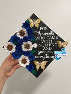 a hand holding up a graduation cap with flowers on it and the words for my parents who came with nothing and gave me everything