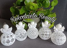 white crocheted ornaments sitting on top of a couch next to a potted plant