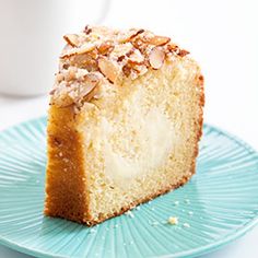 a piece of cake sitting on top of a blue plate next to a white cup