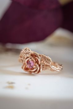 a rose shaped ring with leaves on it