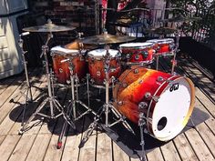 an orange and red drum set sitting on top of a wooden floor