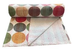 a multicolored polka dot quilt on top of a white blanket