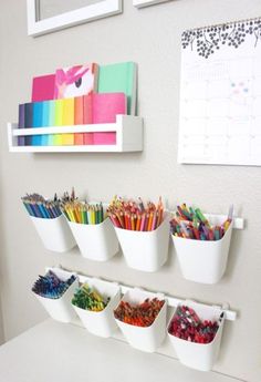 the wall is filled with many different colored pencils and crayons in cups