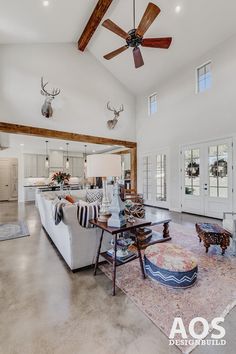 a living room filled with furniture and a ceiling fan in the middle of an open floor plan