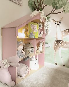 a child's room decorated in pastel pink and white with deer wallpaper