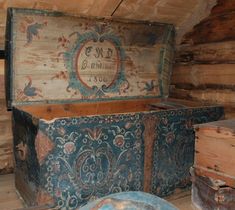 an old wooden box sitting on top of a floor next to other wood boxes and containers