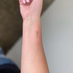 a woman's arm with a small flower tattoo on the left side of her wrist