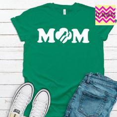 a t - shirt with the word mom on it next to some jeans and sneakers