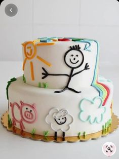 a white cake with colorful frosting and cartoon characters on it's icing