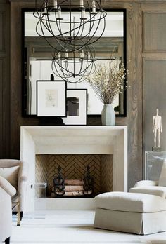 a living room filled with furniture and a fire place in front of a mirror on the wall