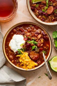 easy slow cooker chili with sausage in a bowl, topped with sour cream and jalapenos