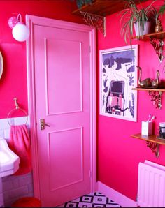 a bathroom with pink walls and shelving on the wall next to a white sink