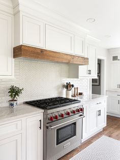 a kitchen with white cabinets and an oven