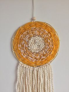 an orange and white dream catcher hanging on a wall