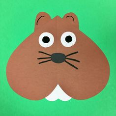 a paper cut out of a cat's face on a green background