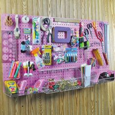 there is a pink peg board with many items on it