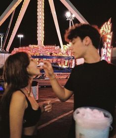 two people eating food at an amusement park