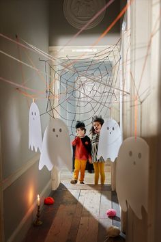 two children standing in front of halloween decorations