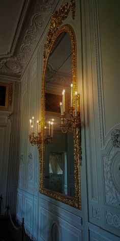 a large mirror hanging on the wall next to a chandelier