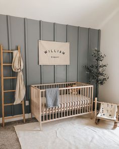 a baby's room with a wooden crib, ladder and blanket on the floor