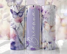 three metal cups with butterflies and flowers on them