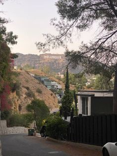 the hollywood sign is on top of a hill in front of some trees and buildings