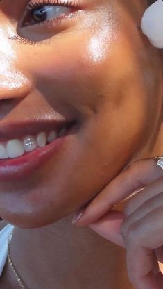 a woman with flowers on her head smiles at the camera while wearing a necklace and ring