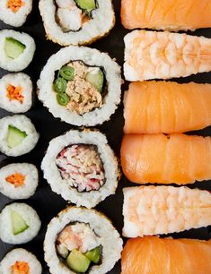 sushi rolls are arranged on a black surface