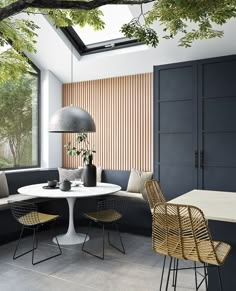 a living room filled with furniture next to a window covered in plants and greenery