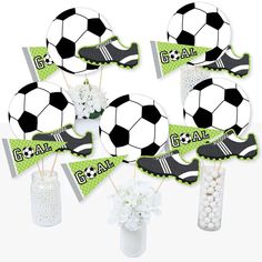 a bunch of soccer themed party items in vases with flowers and balls on them