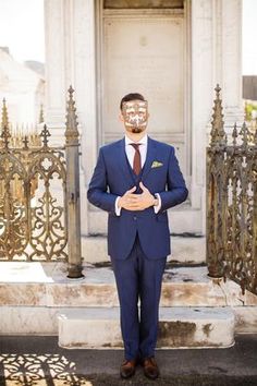 a man in a blue suit with a mask on his face