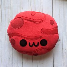 a red stuffed animal sitting on top of a white wooden floor