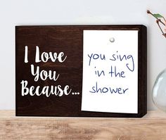 a wooden sign that says i love you sing in the shower with a note attached to it